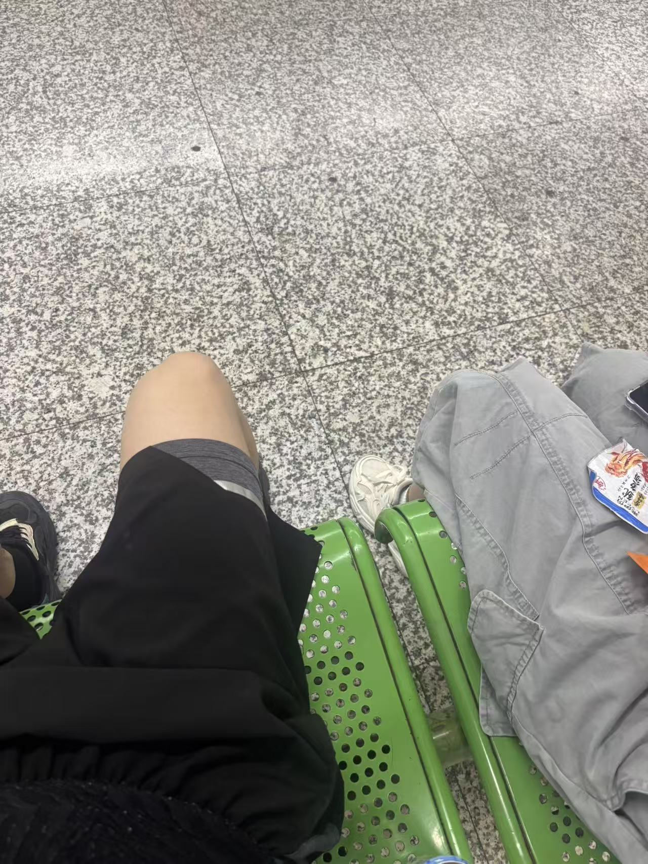 并排坐在绿色椅子上的两个人
