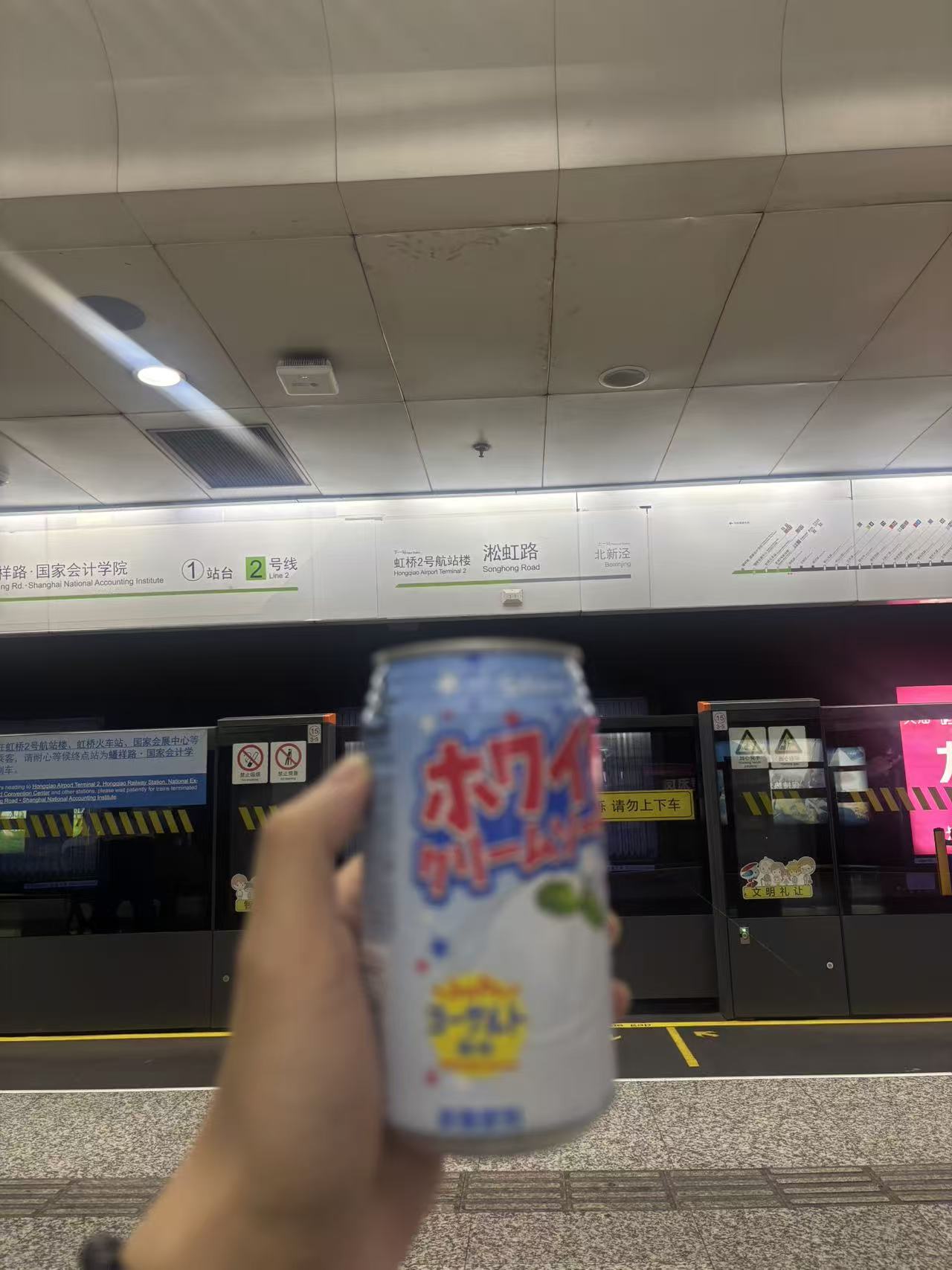 淞虹路站台前举起的一罐饮料
